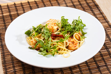 Pasta with shrimp and arugula.