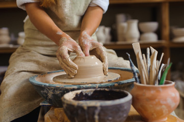 hands of a potter, creating an earthen jar on the circle
