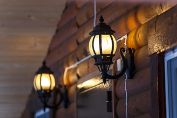 Warm light of external lamps on the house wall