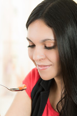 Beautiful young brunette girl enjoying a bite of seafood