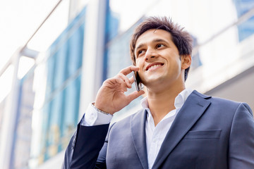 Portrait of confident businessman with mobile phone outdoors