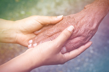 Senior and young holding hands with vintage color tone