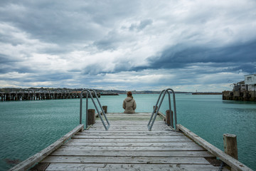 woman sit at the edge of the bridge