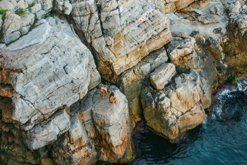 Two girls on the ocean rocks