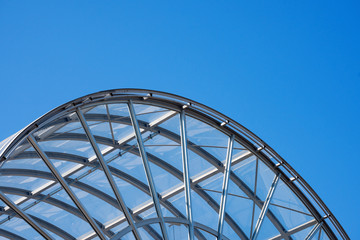 Architectural Details of a Glass and Steel Building / Detail of steel and glass roof of a modern building with blue clear sky
