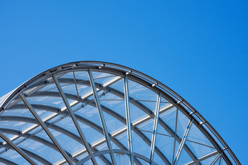 Architectural Details of a Glass and Steel Building / Detail of steel and glass roof of a modern building with blue clear sky

