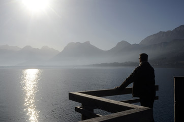 Man looking at Annecy lake and mountains