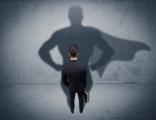 Successful businessman with superhero shadow