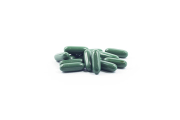 Green capsule pills on white background