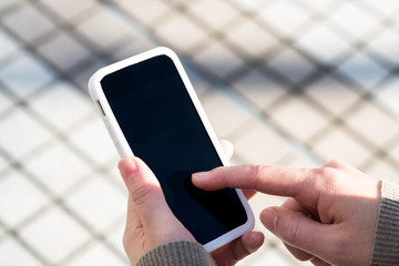 スマホをタッチする女性の手