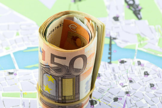 Fifty Euro rolled up on a map as a background
