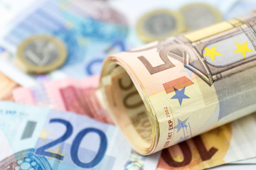 Fifty Euro rolled up on a euro banknotes as a background
