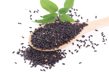 Riso nero in un cucchiaio con foglie aromatiche