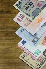 Banknoten großer Volkswirtschaften auf Holzhintergrund