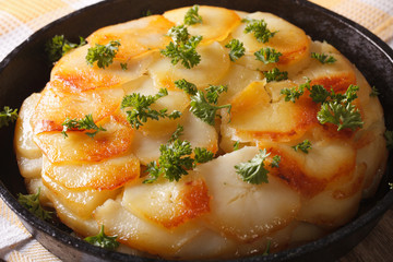French Anna Potatoes baked in a pan close-up. horizontal
