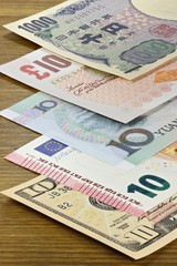 Banknoten großer Volkswirtschaften auf Holzhintergrund