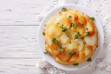 Anna potatoes with butter on a plate. Horizontal top view
