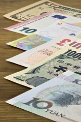 Banknoten großer Volkswirtschaften auf Holzhintergrund