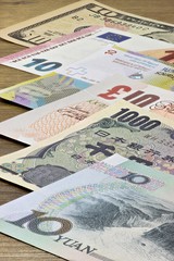 Banknoten großer Volkswirtschaften auf Holzhintergrund