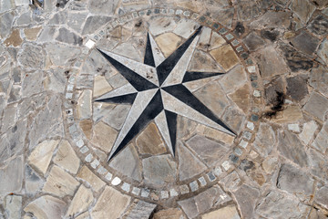 Pavement Stone with Compass Rose / Stone flooring with compass rose 8 directions. A pier in Liguria harbor, italy