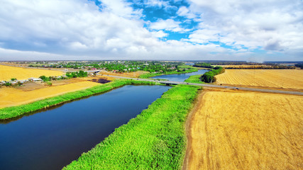 Rural, rustic landscape with river and wheat fields in summer da