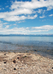 Lake Tahoe shore with rocks and snow mountains