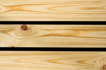 Obraz na płótnie Canvas Background of raw wooden pine planks or boards showing woodgrain texture with gaps