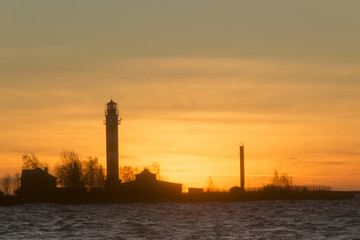 sunset at harbour with silhouette of lighthouse