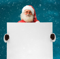 Real Santa Claus holding white blank sign for your text / Merry Christmas & New Year's Eve concept...