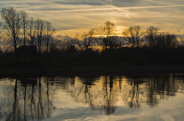 Obraz premium sunset at river with trees reflection on water