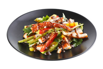 Salad with eel and avocado on a black plate. Isolated on white b