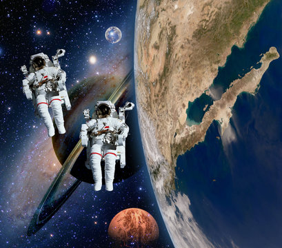 Two astronauts spaceman solar system saturn mars planet moon sci fi space. Elements of this image furnished by NASA.