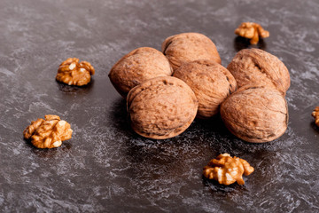 Walnut kernels and whole walnuts on black table