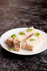 oat bar with coconut with mint on a plate, close up