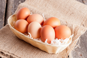 Eggs in Wicker basket on a wooden background