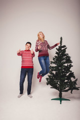 Fototapeta premium happy couple jumping near the Christmas tree