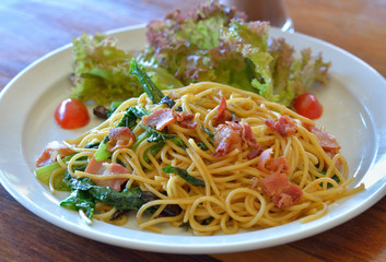 spaghetti with bacon on white plate