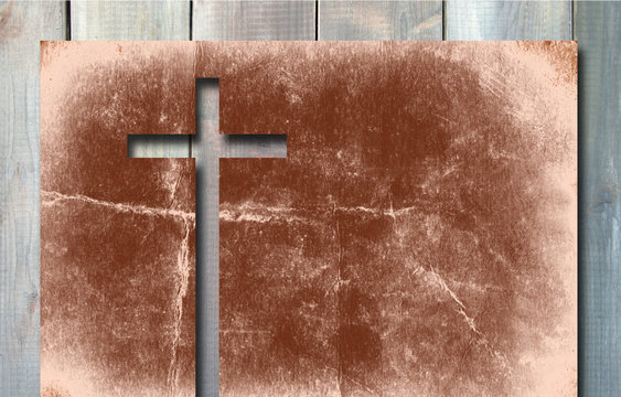 Old vintage Christian paper cross on wood background