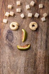 funny food face made with fig, parmesan and taralli on wood