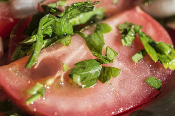 Parts of fresh ripe tomatoes and cut greens