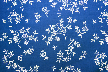 Closeup of blue cotton fabric with flowers.