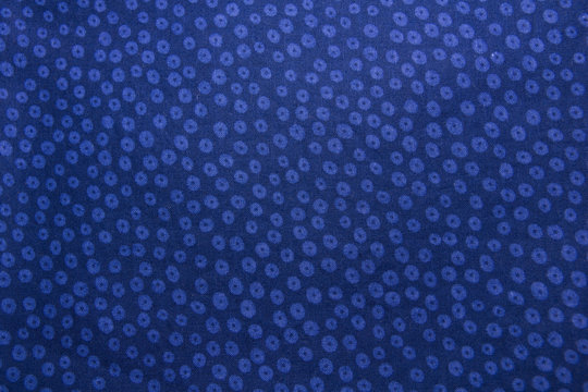 Closeup of blue cotton fabric with flowers.