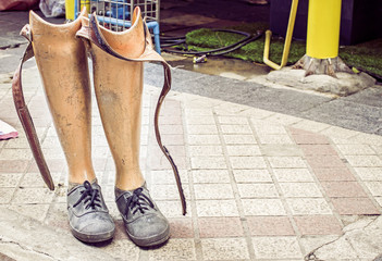 Old prosthetic legs set on a cement floor. Outdoor view