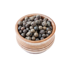 Black pepper in wooden bowl on the white background, top view