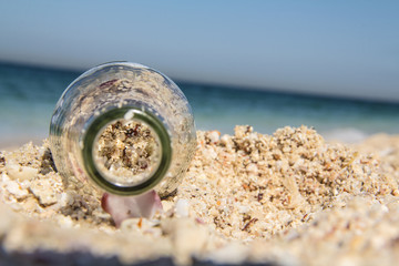 Fototapeta na wymiar Full of Sand / A Coca-cola bottle filled with beach sand.