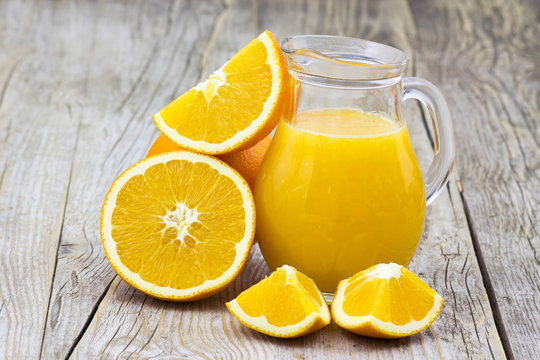 orange juice and fresh fruits on wooden background
