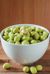 Peanut in white bowl on wooden table