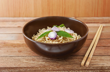 Noodle in brown bowl with wooden chopsticks