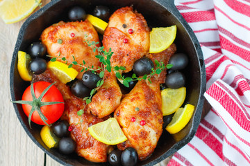 Roast chicken with lemon, olives, tomatoes and thyme. Dinner in a rustic style