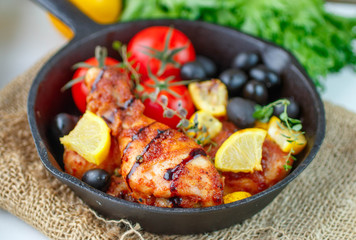 Roast chicken with lemon, olives, tomatoes and thyme. Dinner in a rustic style